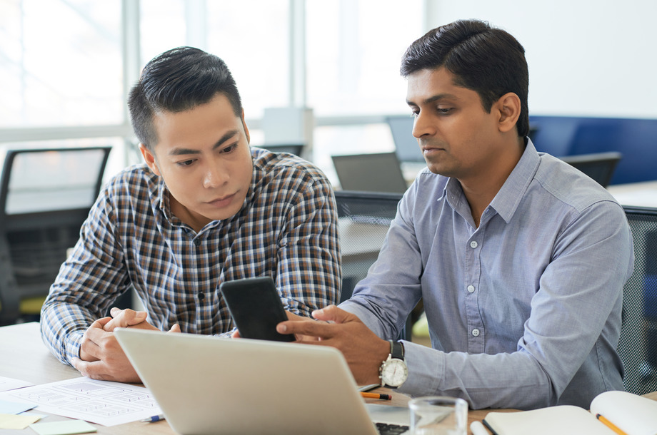 Serious coworkers discussing design of mobile application